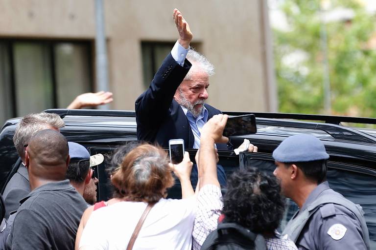 O ex-presidente Lula deixa o velório do seu neto Arthur Lula da Silva, vítima de uma meningite. Ele acena para apoiadores antes de entrar no carro. 