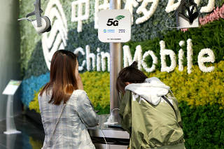 Customers are seen at a China Mobile flagship store displaying smart home experience with 5G network in Shanghai