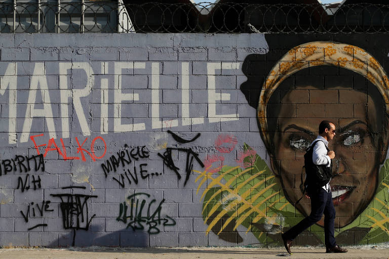 Homem passa à frente de muro com grafite de Marielle Franco no Rio