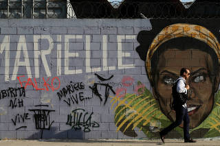 A man walks past a wall with an image of murdered activist and councilwoman Marielle Franco, in Rio de Janeiro