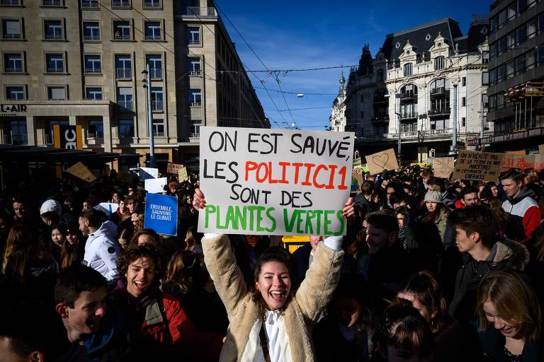 Em Lausanne, estudante mostra cartaz que diz "estamos salvos, os políticos são plantas verdes"; milhares de estudantes se mobilizaram na Suíça no dia 18 de janeiro