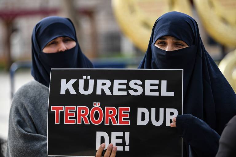 Manifestantes da mesquita Fatih, em Istanbul, seguram cartazes de protesto em resposta aos atentados na Nova Zelândia