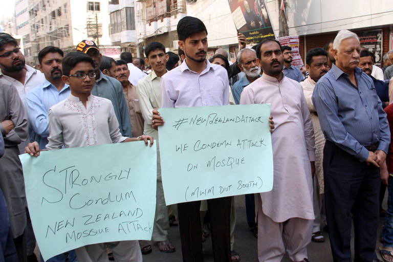 Manifestantes em Karachi, no Paquistão, seguram cartazes condenando os atentados na Nova Zelândia