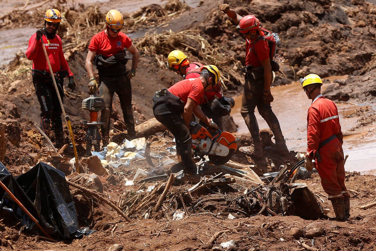 Membros de equipe de resgate procuram vítimas em meio à lama em Brumadinho (MG)