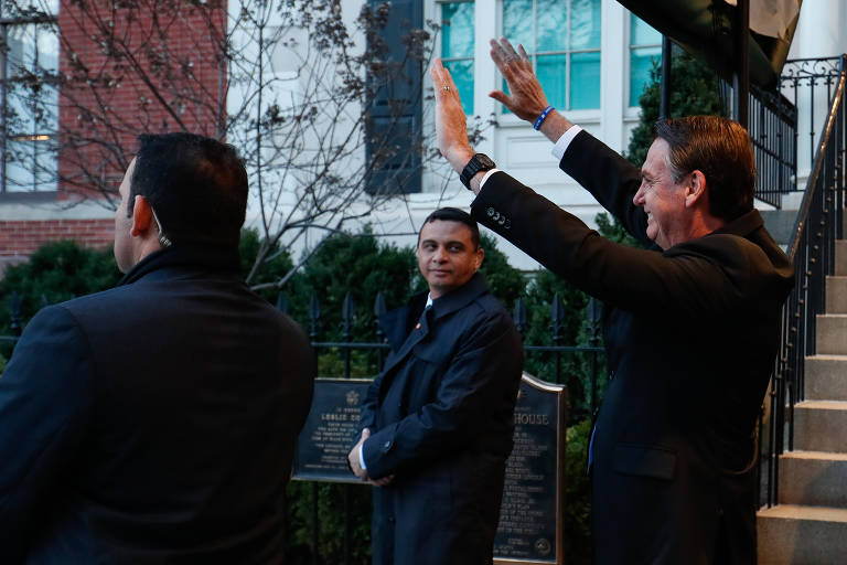 Bolsonaro acena ao sair da Blair House, onde está hospedado durante a visita a Washington