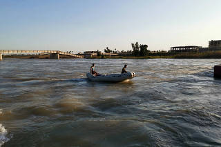 Iraqi rescuers search for survivors over the site where an overloaded ferry sank in the Tigris river near Mosul in Iraq