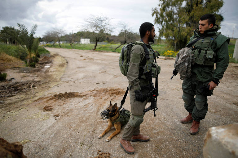 Soldados israelenses com um cachorro, próximo à fronteira com Gaza, ao sul de Israel