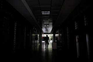 A man walks at the hallway of a building during a blackout in Caracas