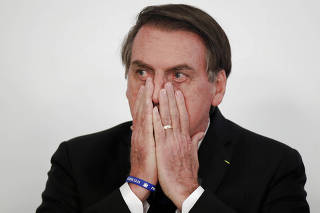 Brazil's President Jair Bolsonaro gestures during a signing ceremony for 13.2 billion reais in contracts for electricity transmission lines, at the Planalto Palace in Brasilia