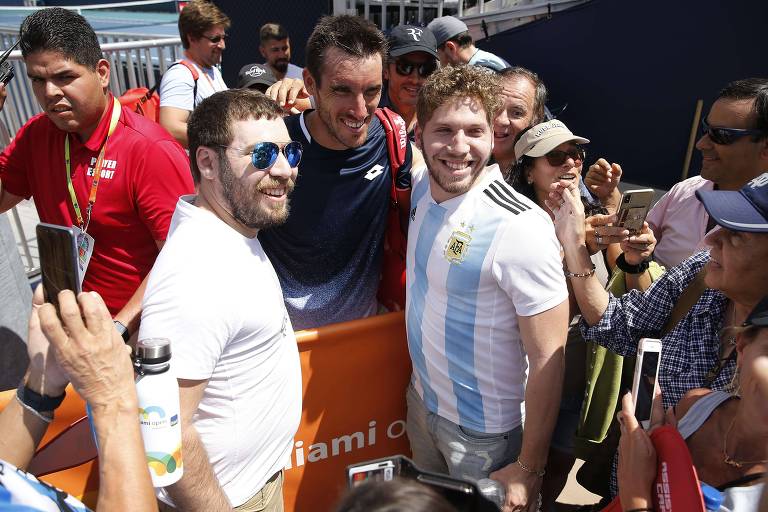 Leonardo Mayer, da Argentina, tira foto com fãs com a camisa da seleção do país.