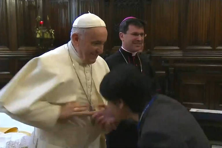 Imagem retirada de vídeo mostra o papa Francisco recolhendo sua mão enquanto uma fiel tenta alcançá-la para beijar o anel papal 
