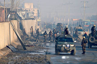 FILE PHOTO: Afghan security forces inspect the site of a car bomb blast at green village in Kabul, Afghanistan