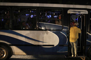 Passengers board a bus during a blackout in Caracas, Venezuela