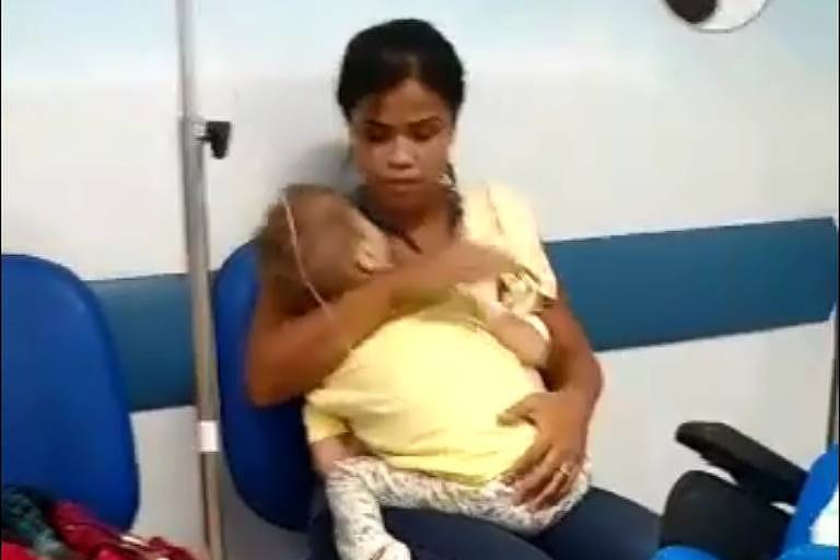 Mãe e garoto aguardam atendimento sentados no corredor do hospital