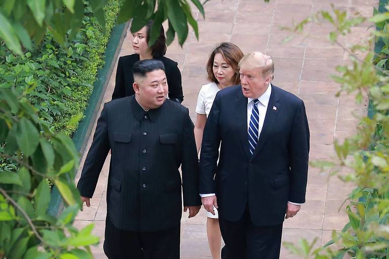 O ditador Kim Jong-un, à esq., e o presidente Donald Trump nos jardins de hotel em Hanói, Vietnã