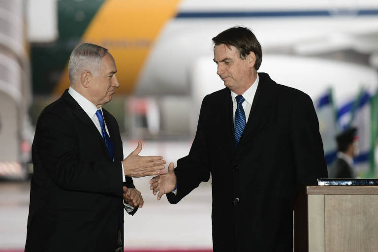 O presidente Jair Bolsonaro, à dir., cumprimenta o premiê de Israel, Binyamin Netanyahu, no aeroporto Ben Gurion, próximo a Tel Aviv