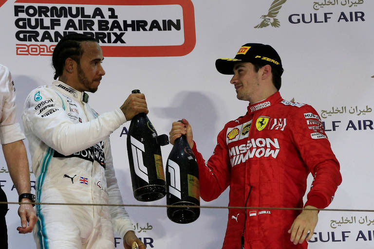 Lewis Hamilton, da Mercedes, brinda com Charles Leclerc, piloto da Ferrari, no pódio do GP do Barein