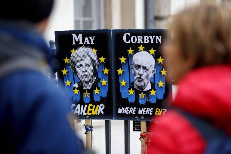 Cartazes com os rostos de Theresa May e Jeremy Corbyn são expostos nas proximidades do Parlamento britânico 