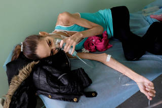 FILE PHOTO: An HIV-positive and tuberculosis patient lies on a stretcher at the Jose Gregorio Hernandez hospital in Caracas