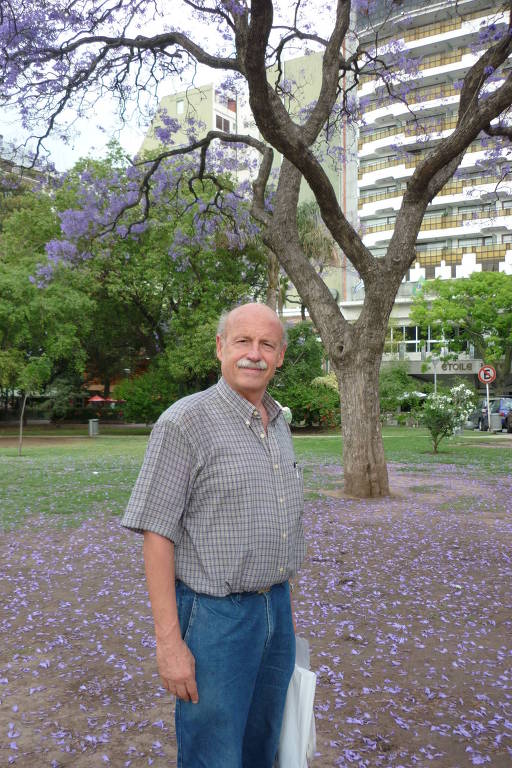 O psicólogo cubano Fernando Luís González Rey em frente a uma árvore com flores lilás