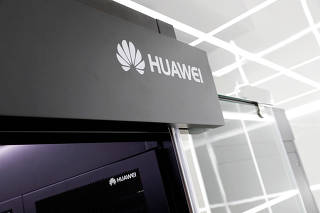 FILE PHOTO: Logos of Huawei are seen on a device at its showroom in Shenzhen, Guangdong province