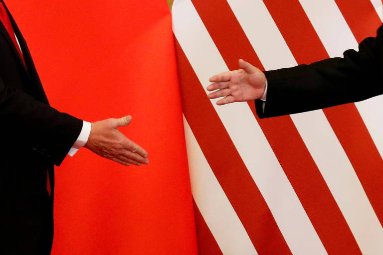 Donald Trump e Xi Jinping se cumprimentam em encontro em Pequim em 2017, antes do início da guerra comercial
