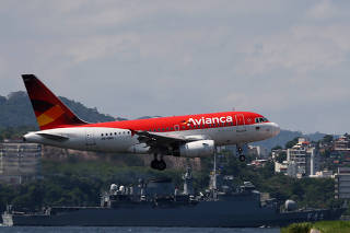 An airplane of Avianca flies over the Guanabara Bay as it prepares to land at Santos Dumont airport in Rio de Janeiro