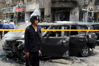 FILE PHOTO: Police officers investigate the site of a car bomb attack on the convoy of Egyptian public prosecutor Hisham Barakat near his house at Heliopolis district in Cairo