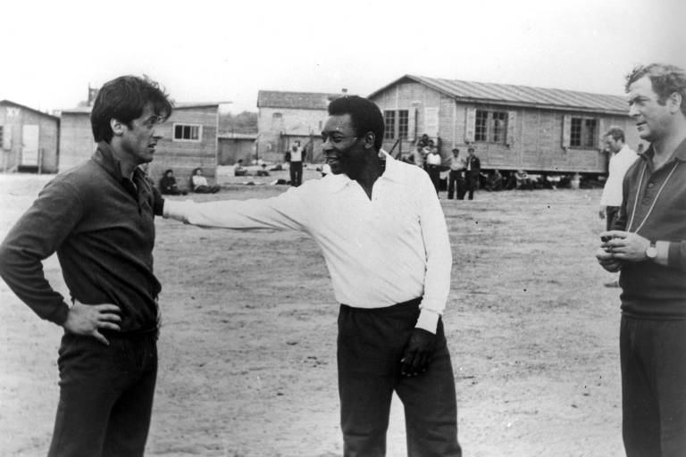 Da esq. para a dir., os atores Sylvester Stallone, o jogador de futebol Pelé e Michael Caine em cena do filme 'Fuga para Vitória', de John Huston