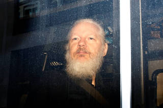 WikiLeaks founder Julian Assange is seen in a police van, after he was arrested by British police, in London