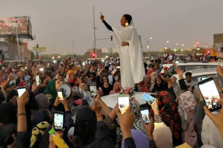 A Sudanese woman gestures during a protest demanding Sudanese President Omar Al-Bashir to step down along a bridge in Khartoum