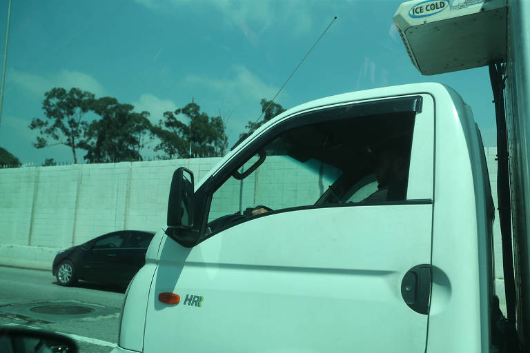 Motorista manuseia celular na marginal Pinheiros, no sentido Interlagos