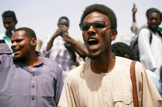 A Sudanese demonstrator chants slogans during a protest against the army's announcement that President Omar al-Bashir would be replaced by a military-led transitional council, ahead of the Friday prayers near Defence Ministry in Khartoum