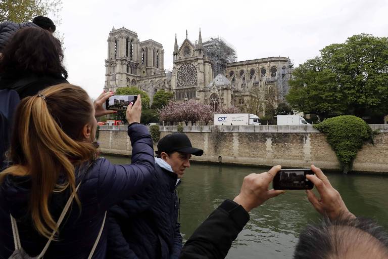 Parisienses e turistas lotam margens do Sena para ver Notre-Dame após incêndio