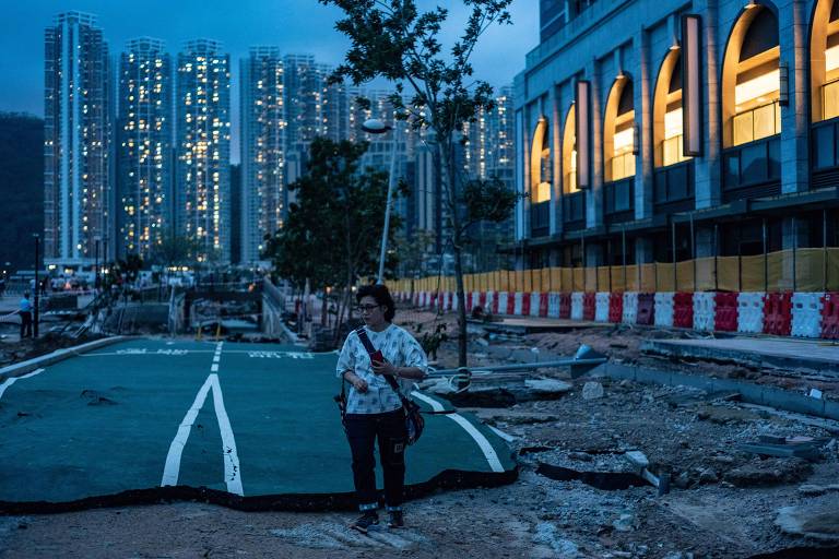 Mulher anda em rua destruída pelo tufão Mangkhut em Hong Kong 