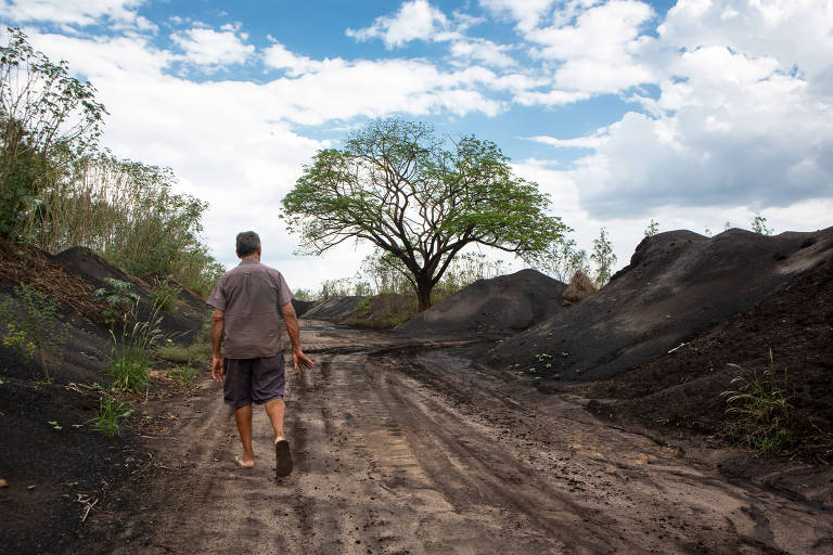 Antônio Araújo, morador de Açailândia, caminha ao lado das montanhas de resíduos inflamáveis