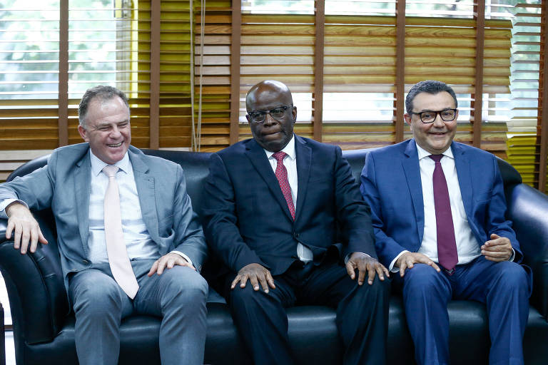 Ex-governador do Espírito Santo, Renato Casagrande; Ex-presidente do STF, Joaquim Barbosa; e o presidente do PSB, Carlos Siqueira, sentado lado-a-lado em um sofá preto.