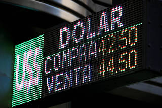 FILE PHOTO: An electronic board shows currency rates in Buenos Aires' financial district