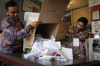 Electoral officials count ballots at a polling center during elections in Surabaya