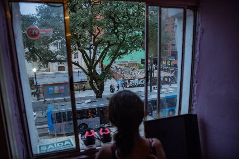 Criança olha para escombros do prédio Wilton Paes de Almeida de janela de ocupação no centro de SP