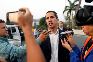 Venezuelan opposition leader Juan Guaido talks to the media outside Generalisimo Francisco de Miranda Airbase in Caracas