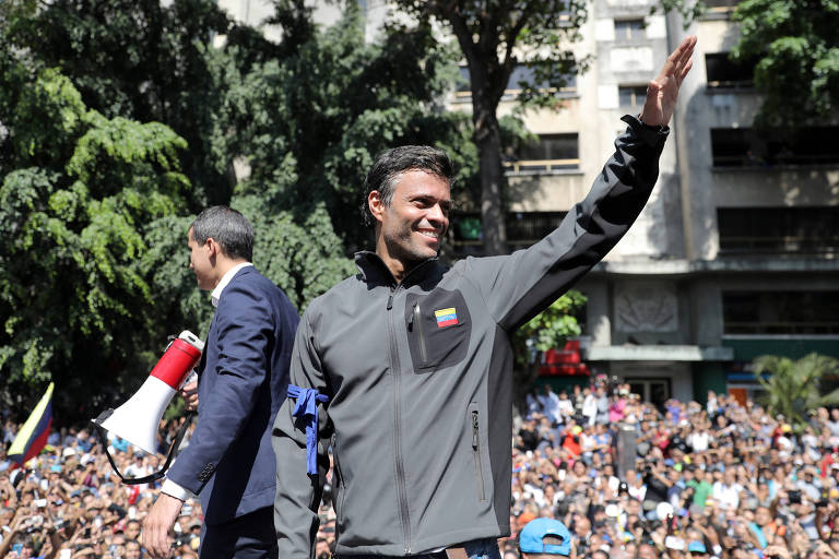 O opositor venezuelano Leopoldo Lopez (de cinza) ao lado de Juan Guaidó diante de apoiadores em Caracas nesta terça (30) 