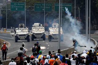 Opposition demonstrators face military vehicles near the Generalisimo Francisco de Miranda Airbase 