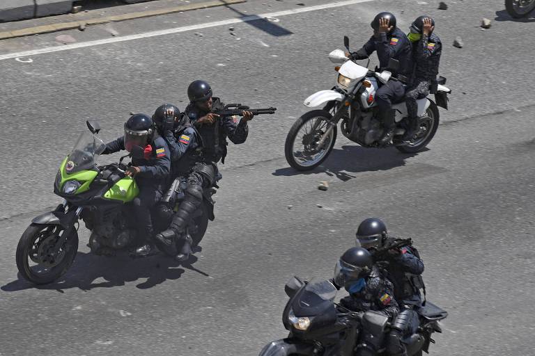Membros da Guarda Nacional Bolivariana disparam contra manifestantes durante protestos contra Maduro em Caracas