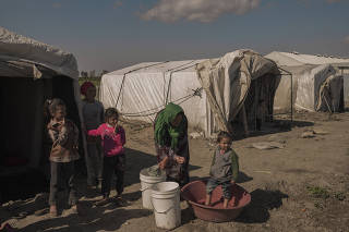 Refugees living inside tents next to orange fields in Adanaana, Turkey.