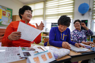 From left: Hwang Wol-geum, 70, Kim Mae-ye, 64, and Park Jong-sim, 75, take reading lessons at Daegu Elementary, in Gangjin County, South Korea.