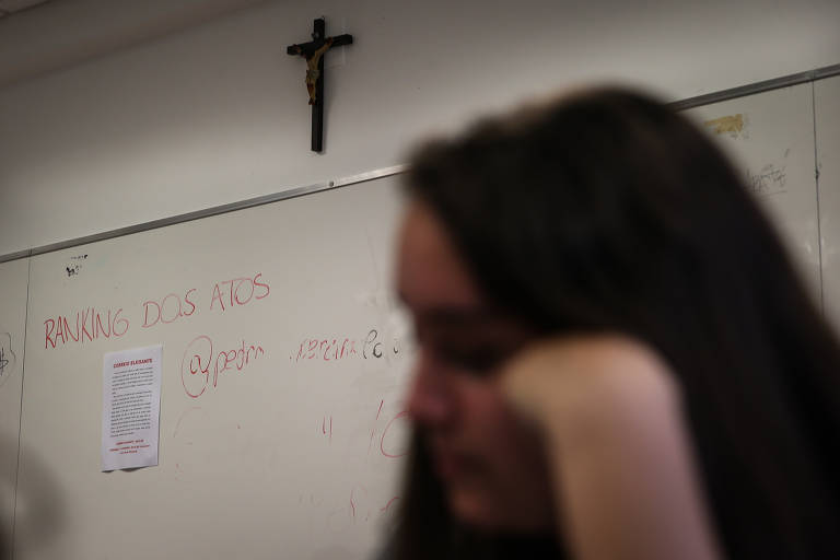 Aluna no Colégio Santa Maria, em SP, em sala de aula com crucifixo