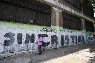 A pedestrian walks past graffiti in Buenos Aires