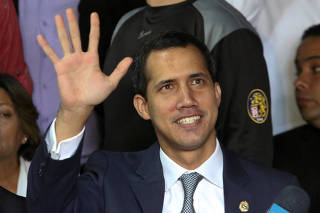 Venezuelan opposition leader Juan Guaido, who many nations have recognised as the country's rightful interim ruler, waves as he arrives for a news conference in Caracas