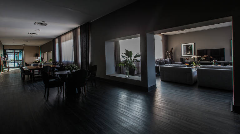 Sala de TV e, atrás, mesas da sala de jantar após a reforma de Doria